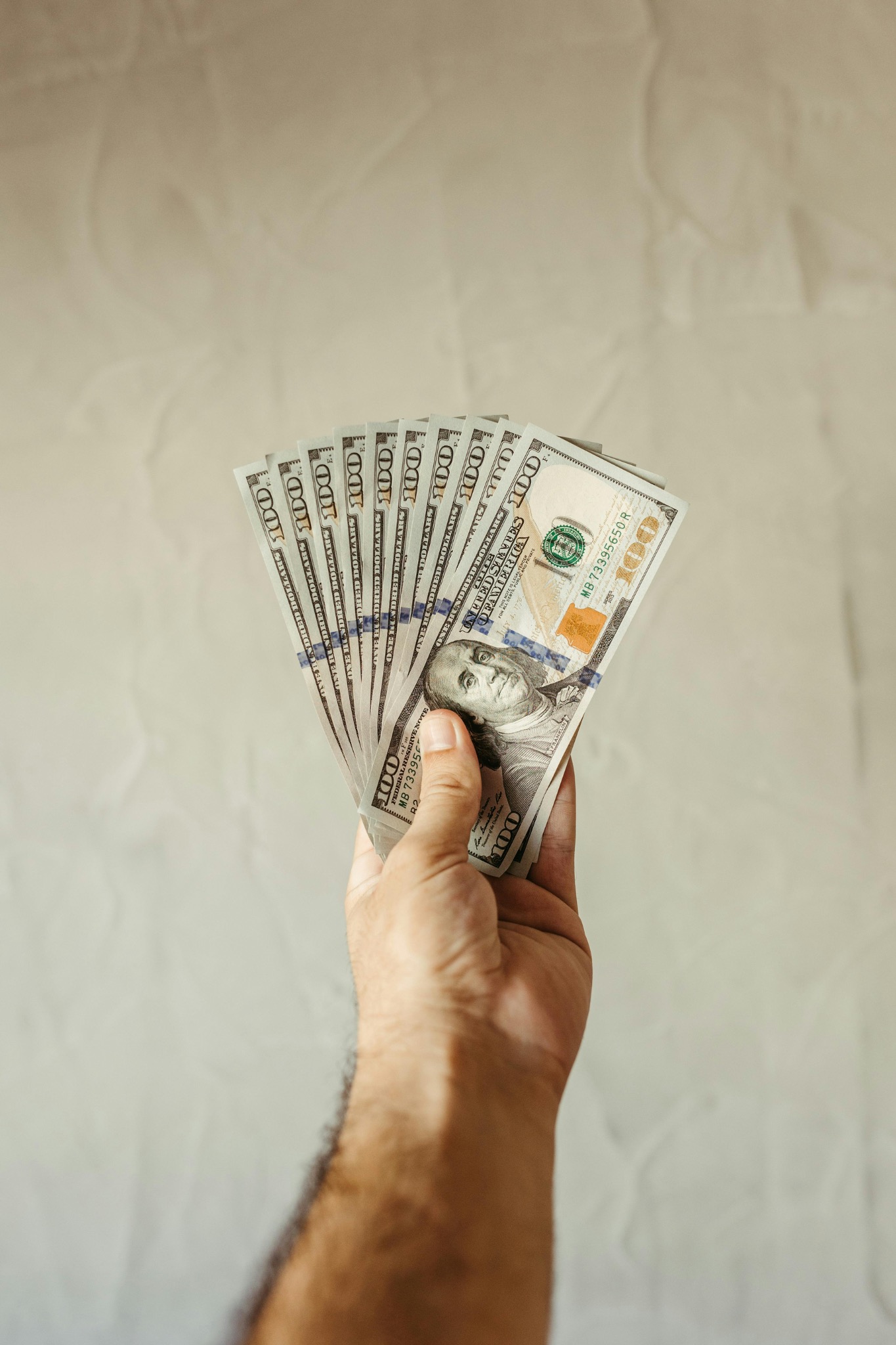 Hand holding cash for a direct cash offer